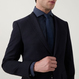 Model wearing Hugo Boss dark blue single cuff regular cotton shirt, styled with navy suit jacket and navy tie.
