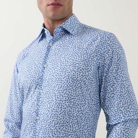 Model wearing Hugo Boss light pastel blue floral print slim fit formal shirt, single cuff, spread collar, close-up torso view