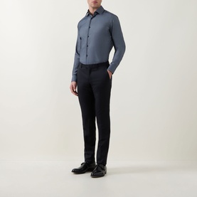 Model wearing Hugo Boss Hank Performance Stretch Single Cuff Shirt in dark blue, styled with black slim trousers and black shoes.