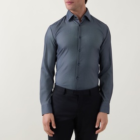 Model wearing Hugo Boss Hank Performance Stretch Shirt in dark blue, styled with black trousers. Slim fit, pointed collar, button front.