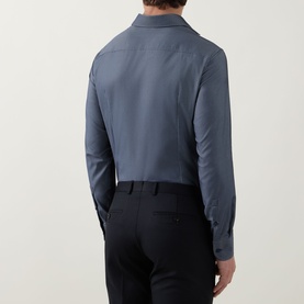 Model wearing Hugo Boss Hank Performance Stretch Single Cuff Shirt in dark blue, rear view, styled with black trousers.