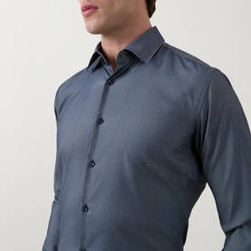 Model wearing Hugo Boss Hank Performance Stretch Shirt in dark blue with pointed collar and navy button fastenings, slim fit