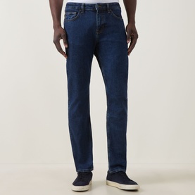 Model wearing Hugo Boss Orange Delaware Slim Fit Jeans in navy, styled with navy slip-on shoes. Slim leg, full length, five-pocket design.
