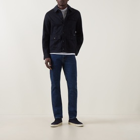 Model wearing Hugo Boss Orange Delaware Slim Fit Jeans in navy, styled with a dark suede jacket, grey top and navy trainers.