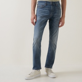 Model wearing Hugo Boss Orange Delaware Mid-Rise Slim Leg Jeans in medium grey, styled with white low-top trainers