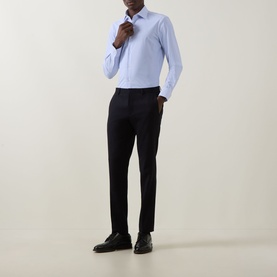 Model wearing Hugo Boss Hank Performance-Stretch Shirt in light blue with black slim-fit trousers and black leather shoes