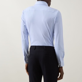 Model wearing Hugo Boss Hank Performance-Stretch Shirt in light blue, back view, single cuff, styled with black trousers