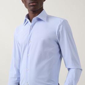 Model wearing Hugo Boss Hank Performance-Stretch Shirt in light blue, slim fit with kent collar, long sleeves and button fastening