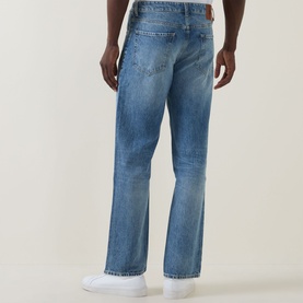 Model wearing Hugo Boss Orange straight jeans in turquoise/aqua wash, rear view, styled with white trainers