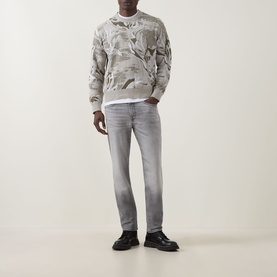 Model wearing Hugo Boss Orange Remained Straight Leg Jeans in light pastel grey with faded detailing, styled with a patterned sweatshirt and black