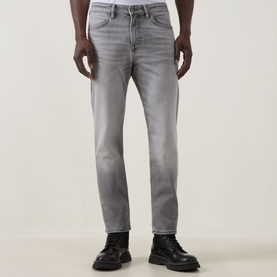 Model wearing Hugo Boss Orange Remained Straight Leg Jeans in light grey with faded whisker detailing, styled with black chunky leather boots.