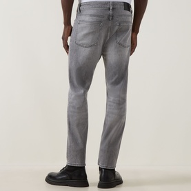 Model wearing Hugo Boss Orange Remained Straight Leg Jeans in light pastel grey with faded detailing, styled with black leather shoes.