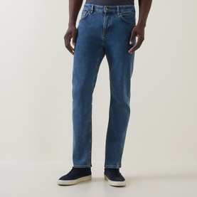 Model wearing Hugo Boss Orange Bright Blue straight-leg jeans in cotton-elastane, styled with navy suede trainers