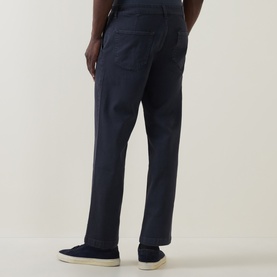 Model wearing Hugo Boss Orange dark blue straight jeans, styled with white low-top trainers, rear view