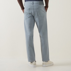 Model wearing Hugo Boss Orange Open Grey straight jeans, rear view, styled with white trainers.