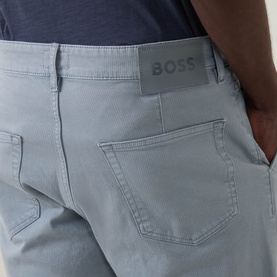 Model wearing Hugo Boss Orange Open Grey straight jeans, close-up rear view showing back pocket with tonal BOSS logo tab
