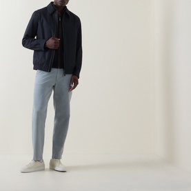 Model wearing Hugo Boss Orange Open Grey straight jeans, styled with a navy bomber jacket and cream trainers.