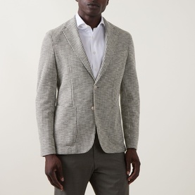 Model wearing Hugo Boss Hanry Houndstooth Single-Breasted Blazer in Open Green, notched lapels, patch pockets, styled with grey trousers and white