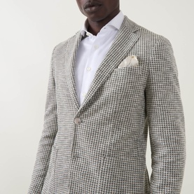 Model wearing Hugo Boss Hanry Houndstooth Single-Breasted Blazer in Open Green, styled with a white shirt and cream pocket square.