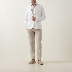 Model wearing Hugo Boss Hanry Single-Breasted Suit Jacket in Open White with beige trousers and tan suede loafers