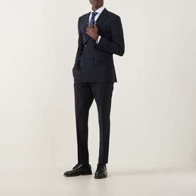 Model wearing Hugo Boss Houston Double-Breasted Suit Jacket in dark blue with peak lapels, styled with matching trousers, white shirt and black shoes.
