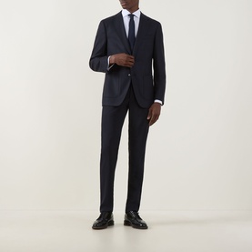 Model wearing Hugo Boss Hutson Single-Breasted Suit Jacket in dark blue wool, styled with matching trousers, white shirt, tie and black shoes