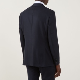 Model wearing Hugo Boss Hutson Single-Breasted Suit Jacket in dark blue wool, rear view showing back vent and buttoned cuffs, styled with white shirt.
