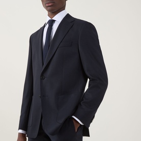 Model wearing Hugo Boss Hutson Single-Breasted Suit Jacket in dark blue wool, styled with matching trousers and black tie