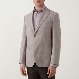 Model wearing Hugo Boss Hutson Single-Breasted Suit Jacket in medium beige with notched lapels, styled with a blue shirt and dark trousers.