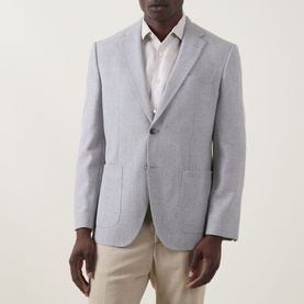 Model wearing Hugo Boss open grey cotton-wool suit jacket with notch lapels and two-button front, styled with beige trousers and white shirt.