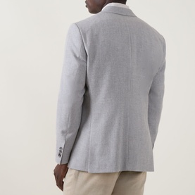 Model wearing Hugo Boss Open Grey cotton-wool suit jacket, back view, styled with cream trousers