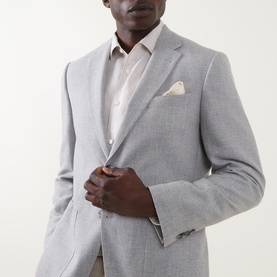 Model wearing Hugo Boss Open Grey cotton-wool suit jacket with notch lapels and cream pocket square, styled with a light shirt.