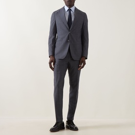 Model wearing Hugo Boss Huge Two-Piece Suit in light blue wool, styled with white shirt and navy tie, slim-leg trousers with pressed creases