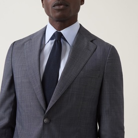 Model wearing Hugo Boss Huge Two-Piece Suit in light blue, single-breasted jacket with notch lapels, styled with white shirt and navy tie