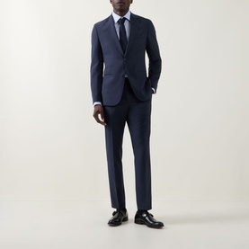 Model wearing Hugo Boss Huge Two-Piece Suit in dark blue, styled with a white shirt, navy tie and black leather shoes.