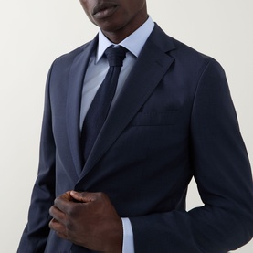 Model wearing Hugo Boss Huge Two-Piece Suit in dark blue wool, styled with a light blue shirt and navy tie