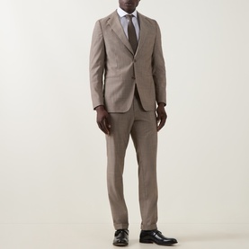 Model wearing Hugo Boss Huge Single-Breasted Two-Piece Suit in dark beige wool, styled with white shirt, grey tie and black Oxford shoes.