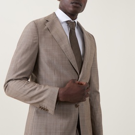 Model wearing Hugo Boss Huge Single-Breasted Two-Piece Suit in dark beige check wool, styled with white shirt and brown tie