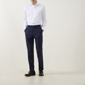 Model wearing Hugo Boss dark blue tailored trousers with slim fit, styled with white dress shirt and black leather shoes