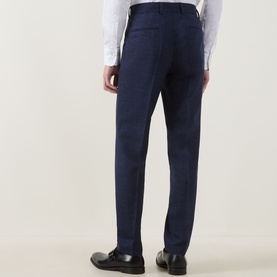 Model wearing Hugo Boss dark blue trousers, rear view, tailored fit with pressed crease, styled with white shirt and black loafers.