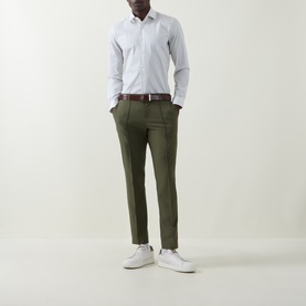 Model wearing Hugo Boss Open Green slim-fit trousers with white shirt, brown belt and white trainers.