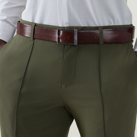 Model wearing Hugo Boss Open Green slim-fit trousers with pleat detail, styled with a burgundy leather belt and white shirt.