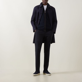 Model wearing Hugo Boss Dark Blue wool-blend trousers, styled with a navy mac coat, zip-through top, and cream slip-on shoes.