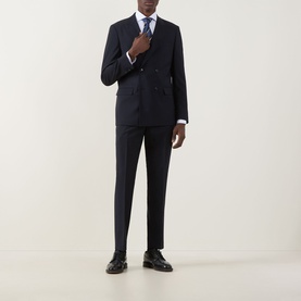 Model wearing Hugo Boss George Slim-Leg Trousers in dark blue, styled with matching double-breasted blazer, white shirt, blue tie and black shoes.
