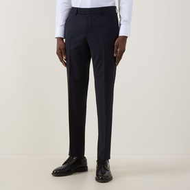 Model wearing Hugo Boss George Slim-Leg Trousers in dark blue with pressed creases, styled with a white shirt and black leather shoes.