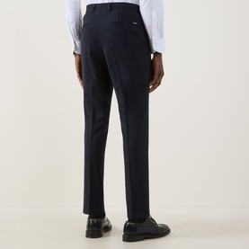 Model wearing Hugo Boss George Slim-Leg Trousers in dark blue, slim fit with pressed creases, styled with white shirt and black leather shoes.