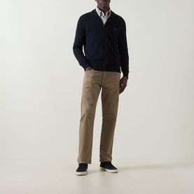 Model wearing Hugo Boss Orange dark blue cotton cashmere zip-through cardigan, styled with white shirt, tan chinos and navy trainers.