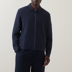 Model wearing Hugo Boss Orange Dark Blue zip-through sweat jacket with collar, styled with matching navy trousers.