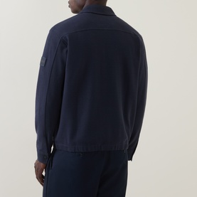 Model wearing Hugo Boss Orange Dark Blue zip-through sweat, rear view showing arm badge detail, styled with matching navy trousers.
