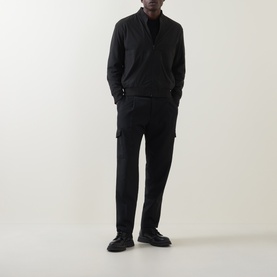 Model wearing Hugo Boss Orange black zip through sweat in polyamide blend, styled with black trousers and black shoes.